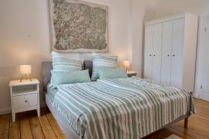 een slaapkamer met een bed met een gestreepte deken bij Ferienwohnung Villa Else in Bad Neuenahr-Ahrweiler