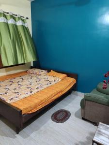 a bedroom with a bed and a blue wall at Hotel Shanti rest house - शांति विश्राम गृह Gaya in Gaya