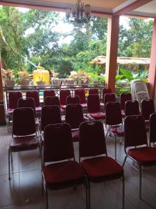 a room with red chairs and a large window at Gloria Guest House in Latuhalat +11 photos