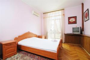 1 dormitorio con 1 cama, TV y ventana en Economy Apartment Center, en Minsk