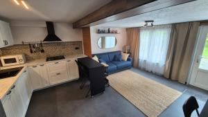 a kitchen and a living room with a blue couch at Studio Rochefort centre 5 minutes à pied in Rochefort