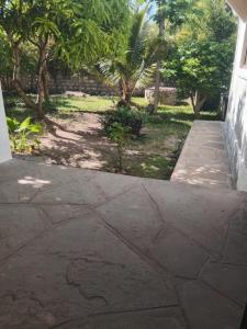 a concrete walkway leading to a yard with trees at Dannys&nickson holiday homes in Watamu