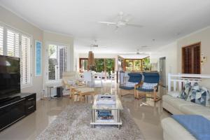 Una sala de estar con un sofá y un televisor. en 15 Nairana Rest Noosa Heads, en Noosa Heads