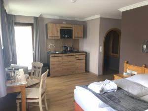 um quarto com uma cama e uma mesa e uma cozinha em Schlossberghof Marzoll em Bad Reichenhall
