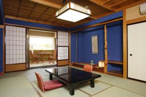 een woonkamer met blauwe muren en een tafel en stoelen bij Yuyaruru Saisai in Kanazawa