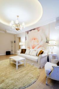ein Wohnzimmer mit einem weißen Sofa und einem Blumenbild in der Unterkunft Kvartira XL in Minsk