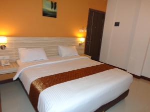 ein Schlafzimmer mit einem großen Bett in einem Hotelzimmer in der Unterkunft Frank's Hotel in Surabaya
