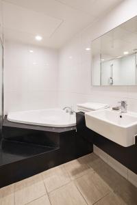 首爾的住宿－首爾G地酒店，带浴缸、水槽和镜子的浴室