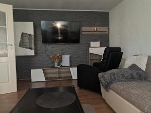 a living room with a couch and a tv on a wall at GuestHouse Marko Belišće in Belišće