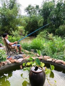 un homme assis sur une chaise et pêchant dans un étang dans l'établissement Homestay Timi, à Nha Trang 22 autres photos