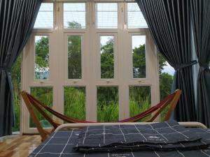 une chambre avec un hamac en face d'une fenêtre dans l'établissement Homestay Timi, à Nha Trang