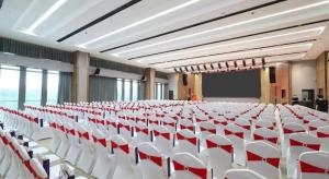 a large room with white tables and white chairs at Zhuhai Hongsanyi Hotel in Zhuhai