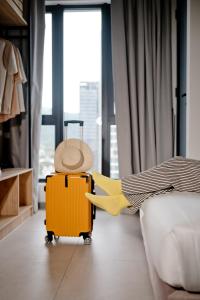 une valise jaune posée à côté d'un lit dans l'établissement 22 Macalisterz George Town By Mana-Mana, à George Town