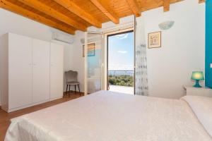 a bedroom with a bed and a large window at Oasi Dell'Etna in Belpasso