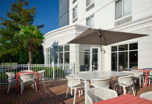 a table and chairs and an umbrella on a patio at Hilton Garden Inn Meridian in Meridian