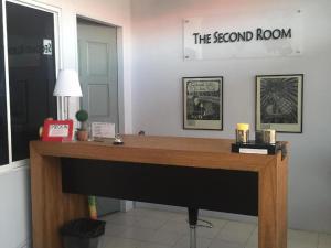 a desk in a room with a sign on the wall at The Second Room in Ranau