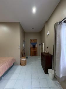 ein Schlafzimmer mit einem Bett und ein Badezimmer mit Dusche in der Unterkunft Well Living Guesthouse Khaolak in Khao Lak