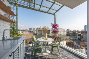 a patio with a table and chairs on a balcony at Twilight Townhouse w Lift in Hanoi