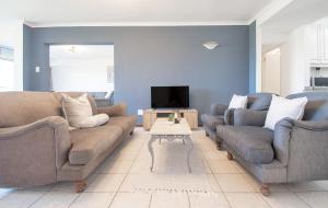 Una sala de estar con dos sofás y un televisor. en 27 Kyalanga Umhlanga Rocks Beachfront, en Durban