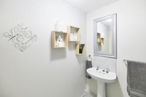 a white bathroom with a sink and a mirror at Talana's Stay - 17 Hugo in Bredasdorp +76 photos
