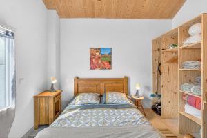 a bedroom with a bed and wooden cabinets at Gîte La Grange Des Pépinières in Saint-Auban-dʼOze