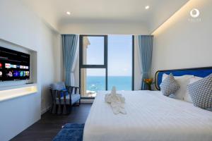 a bedroom with a large bed with a large window at Solara Apartment Firework & Sunset View in Phú Quốc +178 photos