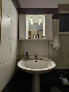 Un baño con un lavabo blanco y un espejo. en HomeLikeNone, en Kastoria 6 fotos más