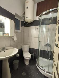 Un baño con inodoro, lavabo y ducha. en HomeLikeNone, en Kastoria