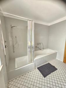 a white bathroom with a tub and a shower at Ferienwohnung Stadtmitte in Braunfels