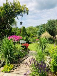 a garden with colorful flowers and a walkway at Apartmán Karin in Huty +58 photos