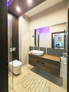a bathroom with a sink and a toilet and a mirror at Tabago Studio 38 Tomaszów Mazowiecki in Tomaszów Mazowiecki