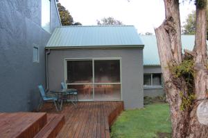 a patio with a table and chairs on a deck at Tui Hideaway in Invercargill