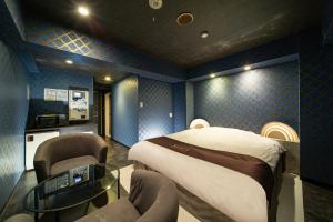 a room with a bed and chairs in it at Hotel Xenia Mikumo (Adult Only) in Konan