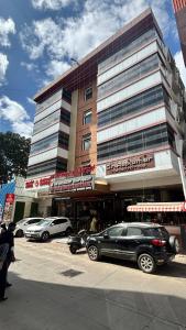 a large building with cars parked in front of it at Hotel Dr Rajkumar International in Bengaluru