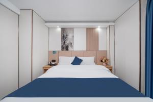 a bedroom with a large bed with blue sheets at Yinuo Hotel - Guangzhou Shangxiajiu Pedestrian Street, Yongqingfang Branch in Guangzhou +18 photos