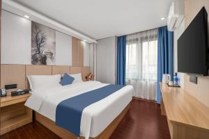 a hotel room with a large bed and a flat screen tv at Yinuo Hotel - Guangzhou Shangxiajiu Pedestrian Street, Yongqingfang Branch in Guangzhou