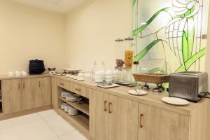 a kitchen with wooden cabinets and a stained glass window at OPO The View, Delhi Airport in New Delhi