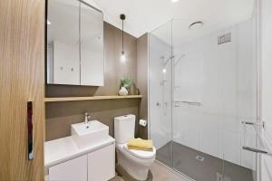 a bathroom with a toilet and a sink and a shower at Bright & Modern 2BR Apt Walk to Central in Melbourne