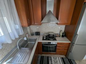 a small kitchen with a sink and a stove at Byron suite in Kavála