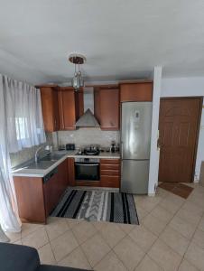 a kitchen with wooden cabinets and a stainless steel refrigerator at Byron suite in Kavála +11 photos