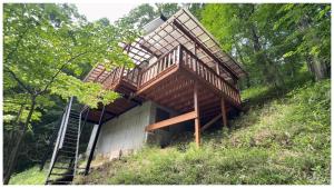 a house with stairs on top of a hill at コテージそら豆ん家 in Nasu