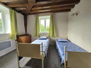 a bedroom with two beds and a window at Appartement chez Claudine in Conches-en-Ouche