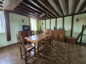 a dining room with a wooden table and chairs at Appartement chez Claudine in Conches-en-Ouche