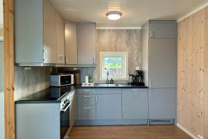 a kitchen with white cabinets and a sink at Rorbu by Nappstraumen, Lofoten in Gravdal