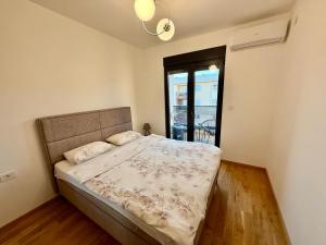 a bedroom with a bed in a room with a window at Apartmants City Love in Podgorica