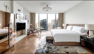 a bedroom with a large bed and a living room at The, Langham Jakarta in Jakarta