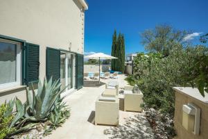 a patio with lounge chairs and an umbrella at Villa Allegra w Private Pool in Škrip