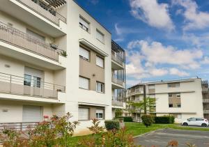 an apartment building with a car parked in front at Le Sunny Side - Appartement pour 4 personnes Disneyland in Montévrain