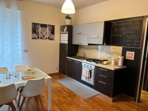 a kitchen with a table and a stove and a counter at Bumbunin in Alba