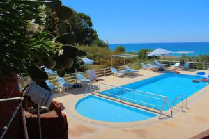 a large swimming pool with lounge chairs at Hotel Schönberg in Kızılot